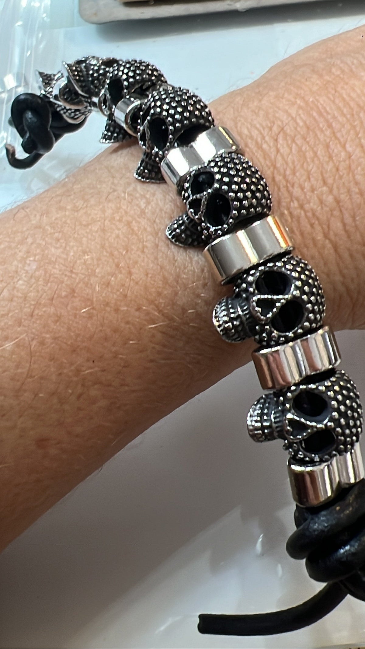 Pulsera de cuero con calaveras de metal plateado